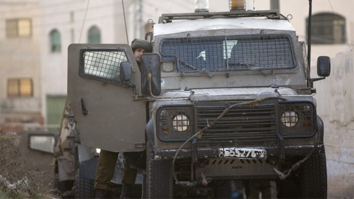 Un soldado israelí junto a un vehículo durante una incursión militar israelí en la ciudad cisjordana de Yenín el 4 de octubre de 2015. (AP Photo/Majdi Mohammed)