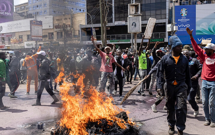 Manifestantes reaccionan junto a neumáticos ardiendo durante una protesta contra la ley de finanzas en Nairobi, Kenia, el 25 de junio de 2024. (Patrick Meinhardt/Getty Images)