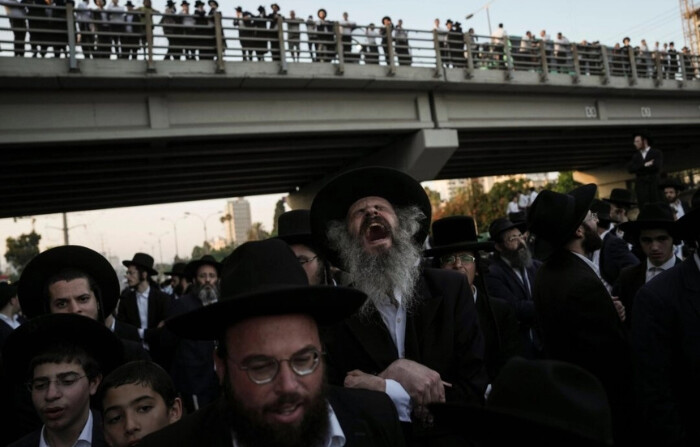 Hombres judíos ultraortodoxos bloquean una carretera durante una protesta contra el reclutamiento en el ejército en Bnei Brak, Israel, el 27 de junio de 2024. (Oded Balilty/Foto AP)
