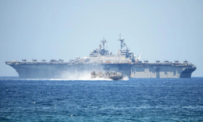 Un aerodeslizador de la Marina de los EE. UU. pasa a toda velocidad junto al USS Wasp, un buque de asalto anfibio multipropósito, durante los ejercicios de desembarco anfibio como parte del ejercicio militar conjunto anual de EE. UU. y Filipinas en las costas de la ciudad de San Antonio, frente al mar de China Meridional, en Filipinas, el 11 de abril de 2019. (Ted Aljibe/AFP vía Getty Images)