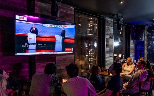 La gente observa el debate presidencial entre el presidente Joe Biden y el expresidente Donald Trump, en un bar de Nueva York el 27 de junio de 2024. (Samira Bouaou/The Epoch Times)