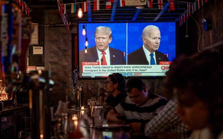 Un grupo de personas observa el debate presidencial entre el presidente Joe Biden y el expresidente Donald Trump, en un bar de Nueva York, el 27 de junio de 2024. (Samira Bouaou/The Epoch Times)
