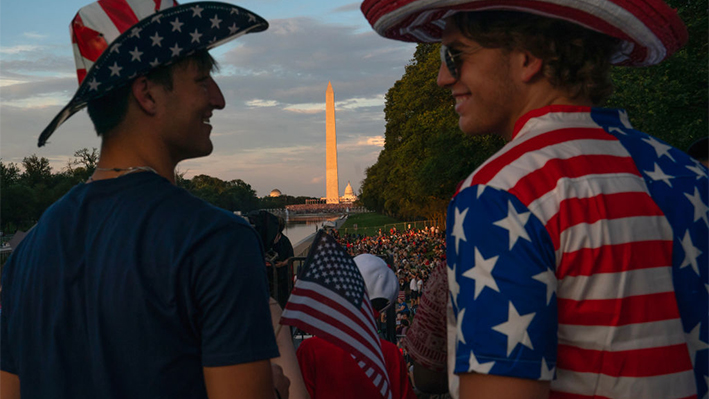 Los asistentes hablan cerca del Monumento a Lincoln antes del espectáculo de fuegos artificiales del Día de la Independencia a lo largo del National Mall el 4 de julio de 2023 en Washington, DC. (Nathan Howard/Getty Images)