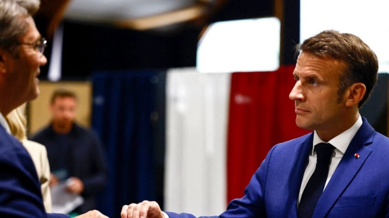 El presidente francés Emmanuel Macron (R) deposita su papeleta para votar en la primera vuelta de las elecciones parlamentarias anticipadas francesas, en Le Touquet-Paris-Plage, norte de Francia, el 30 de junio de 2024. (Yara Nardi, Pool vía AP)