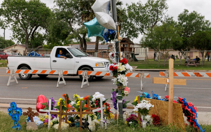 Un pasajero mira un sitio conmemorativo desde un vehículo en movimiento donde 8 migrantes murieron, y otros resultaron heridos el día anterior mientras esperaban en una parada de autobús, en Brownsville, Texas, el 8 de mayo de 2023. (Michael Gonzalez/AP Photo, Archivo)