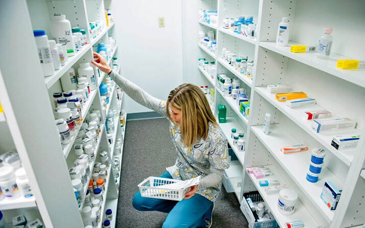 Una empleada clasifica medicamentos mientras busca una receta en una farmacia de Blacksville, Virginia Occidental, el 21 de marzo de 2017. (Brendan Smialowski/AFP vía Getty Images)