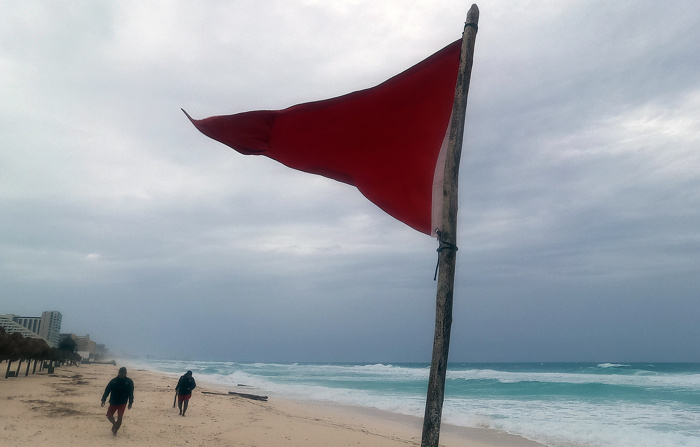 Fotografía de una bandera roja en la playa que indica oleaje agitado y fuertes corrientes debido a la proximidad de la tormenta tropical "Beryl" este sábado, en Cancún, México.  (EFE/Alonso Cupul)