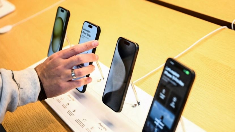 Un cliente compara los dispositivos de la serie iPhone 15 de Apple expuestos a la venta en la tienda de Apple The Grove el día del lanzamiento en Los Ángeles el 22 de septiembre de 2023. (Patrick T. Fallon/AFP vía Getty Images)