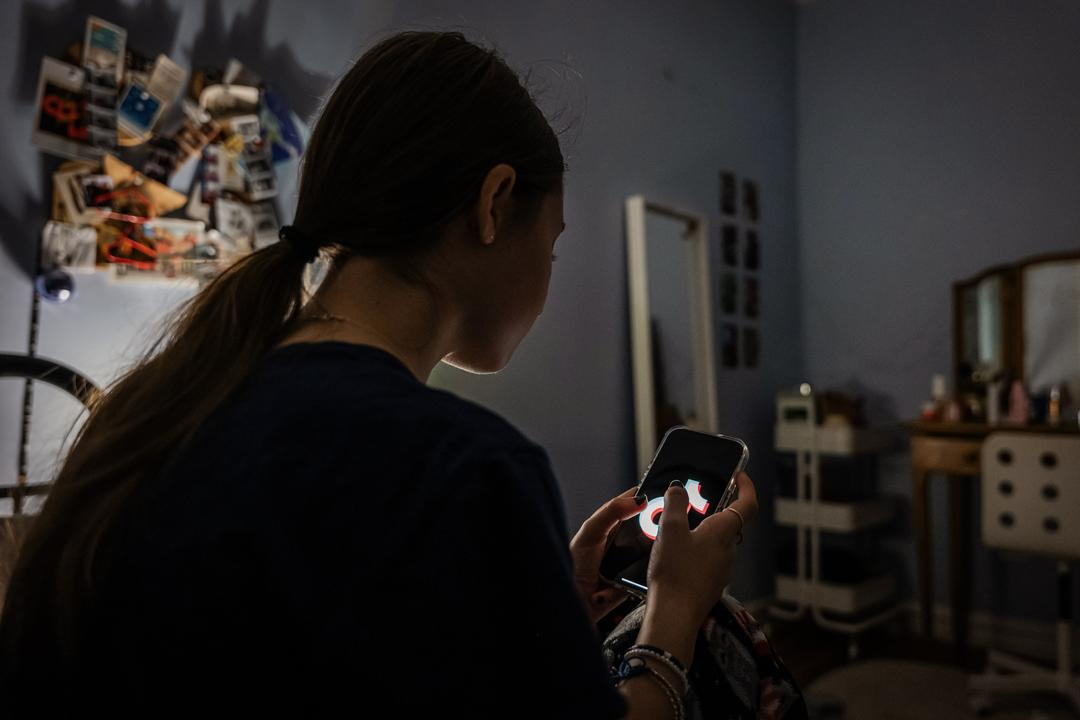 Una adolescente utiliza su teléfono móvil para acceder a las redes sociales, en Nueva York, el 31 de enero de 2024. Los jóvenes suelen sentir curiosidad por los contenidos agresivos, pero sus cerebros no se han desarrollado lo suficiente como para tener en cuenta las consecuencias, según la madre de una víctima. (Spencer Platt/Getty Images)