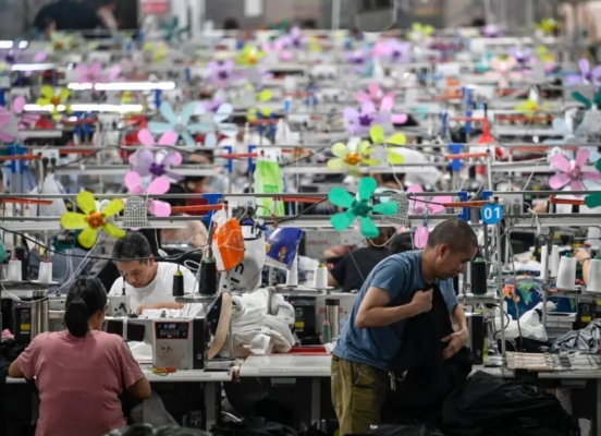 Trabajadores produciendo prendas en una fábrica textil que suministra ropa a la empresa de comercio electrónico de moda rápida Shein en Guangzhou, en la provincia meridional china de Guangdong, el 11 de junio de 2024. (Jade Gao/ AFP vía Getty Images)