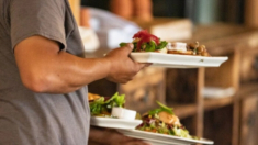 Newsom promulga ley para que restaurantes de California puedan cobrar cargos por servicio