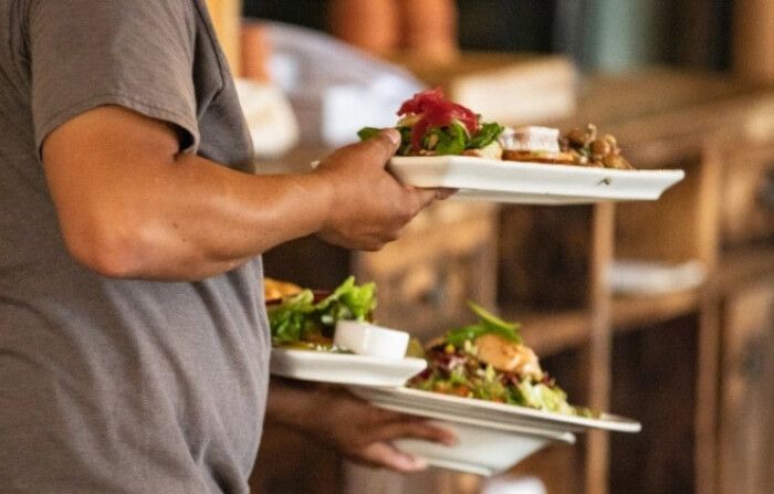 Un camarero lleva comida en un restaurante de Newport Beach, California, el 9 de septiembre de 2020. (John Fredricks/The Epoch Times)
