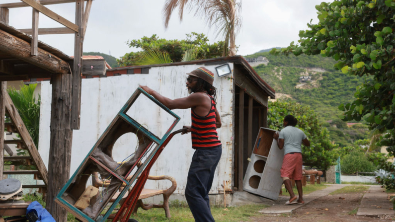 Yogo Dean ayuda a trasladar objetos a un lugar más seguro antes de la llegada del huracán Beryl el 03 de julio de 2024 en Kingston, Jamaica. (Joe Raedle/Getty Images)