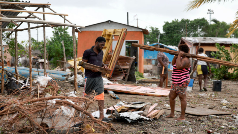 Omar Soloman (i) y Keysha Hill recogen lo que queda de su tienda después de que fuera destruida cuando el huracán Beryl pasó por la zona el 04 de julio de 2024 en Old Harbor, Jamaica. (Joe Raedle/Getty Images)