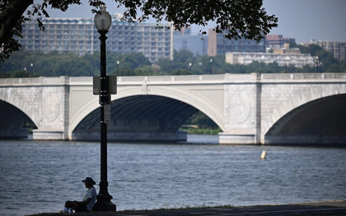 Un hombre se sienta a la sombra junto al río Potomac durante un caluroso día en Washington, D.C., el 7 de septiembre de 2023. (Mandel Ngan /AFP vía Getty Images)