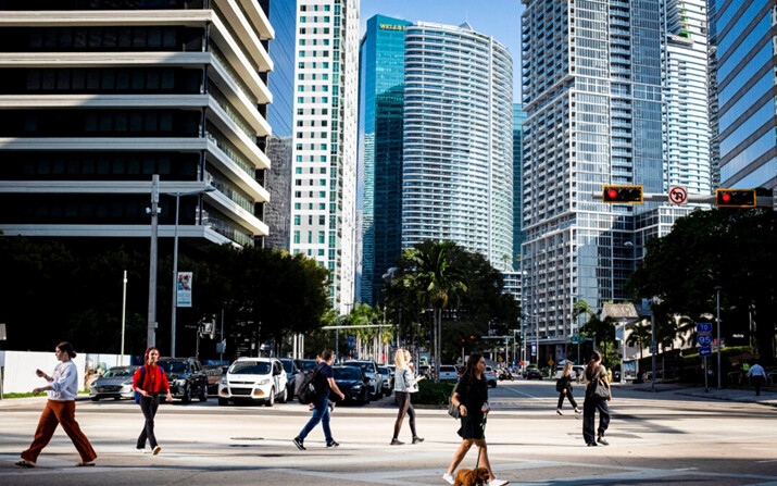 La gente cruza la intersección de SW 8th Steet y Brickell Ave. en el barrio de Brickell, conocido como el distrito financiero, en Miami, Florida, el 23 de febrero de 2023. (Marco Bello/REUTERS)