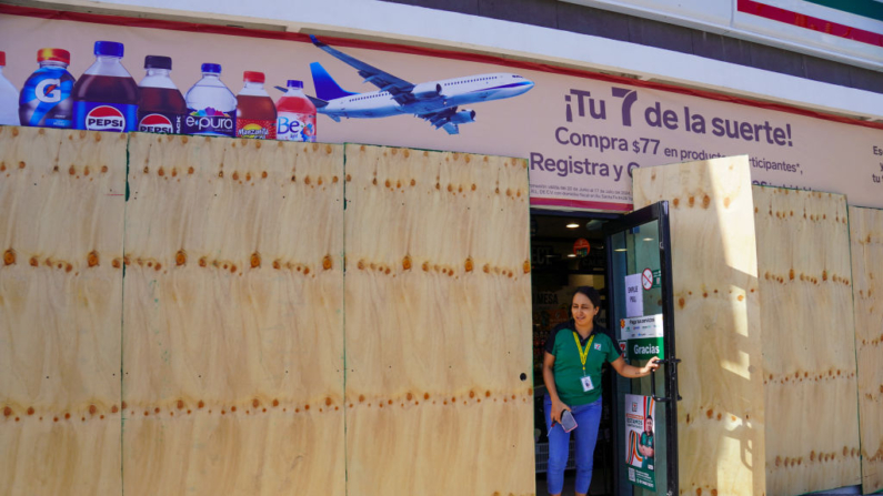 Una mujer sale de una tienda tapiada en Tulum, estado de Quintana Roo, México, el 4 de julio de 2024. (Elizabeth Ruiz/AFP vía Getty Images)