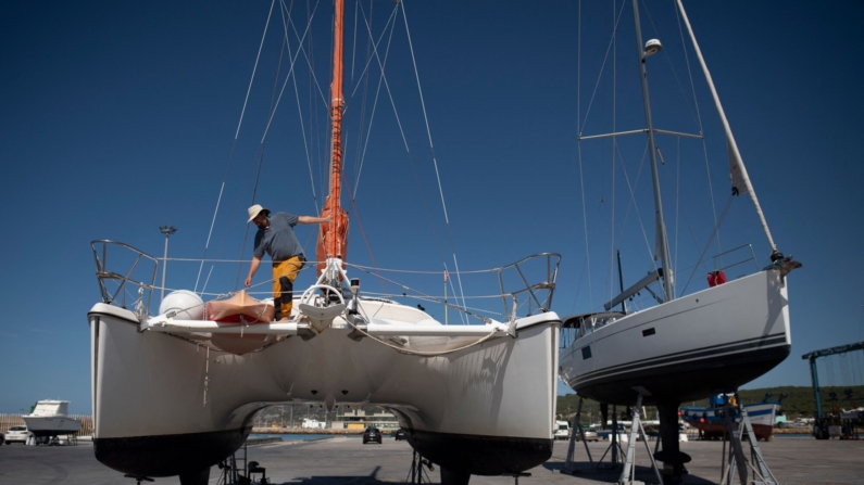 Un hombre trabaja en un catamarán atacado por orcas mientras navegaba en el Estrecho de Gibraltar y llevado a reparar a los Astilleros Pecci de Barbate, cerca de Cádiz, sur de España, el 31 de mayo de 2023. (Foto de JORGE GUERRERO/AFP vía Getty Images)