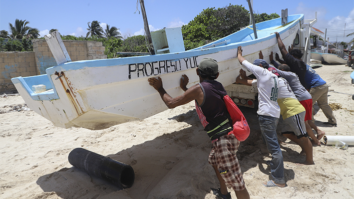 Personas reubican una embarcación para protegerla ante la llegada del huracán Beryl en Progreso, México, el jueves 4 de julio de 2024. (AP Photo/Martin Zetina)
