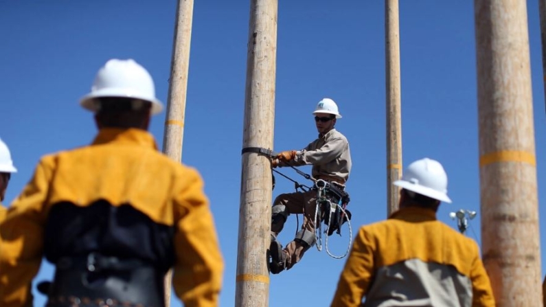 Los estudiantes observan como un instructor de Pacific Gas and Electric muestra cómo navegar por un poste de servicios públicos durante un curso en las instalaciones de formación de PG&E en Oakland, California, el 8 de junio de 2012. (Justin Sullivan/Getty Images)