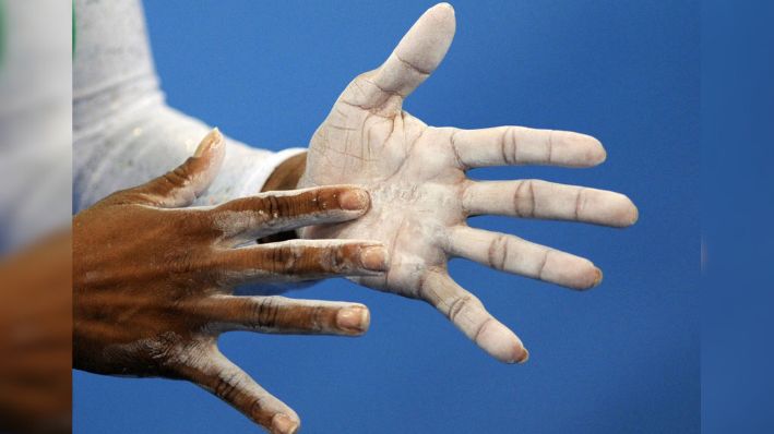 Una mujer se aplica talco en las manos durante la prueba de clasificación femenina de gimnasia artística de los Juegos Olímpicos de Beijing 2008, en Beijing, el 10 de agosto de 2008. (FRANCK FIFE/AFP via Getty Images)