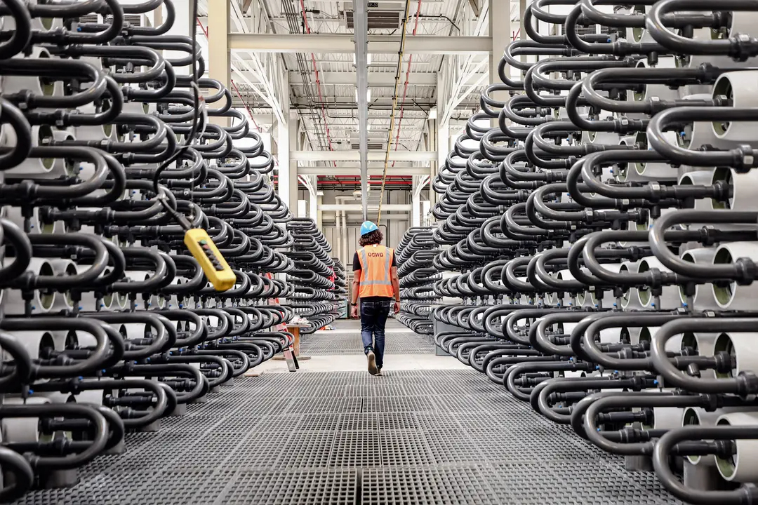 Un miembro del personal del Distrito de Aguas del Condado de Orange camina por el Sistema de Reposición de Aguas Subterráneas en Fountain Valley, California, el 20 de julio de 2022. Según el Sr. Lucci, una de las principales preocupaciones en materia de seguridad nacional es la propiedad extranjera de tierras cerca de infraestructuras como centrales eléctricas y de agua. (Mario Tama/Getty Images)