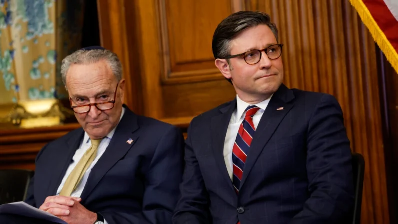 El líder de la mayoría del Senado Chuck Schumer (D-N.Y.) (L) y el presidente de la Cámara Mike Johnson (R-La.) escuchan durante la ceremonia de encendido de la Menorah del Capitolio en el edificio del Capitolio de EE.UU. en Washington el 12 de diciembre de 2023. (Anna Moneymaker/Getty Images)