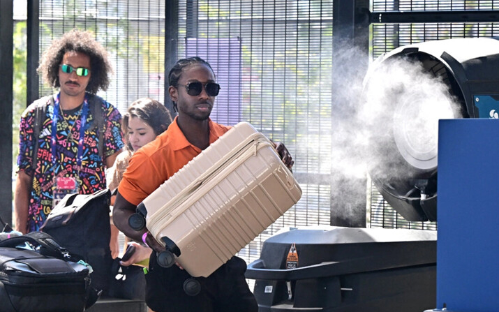 Un ventilador emite spray de agua para refrescar a la gente mientras pasa el control de seguridad en el estadio Allegiant de Las Vegas, el 6 de julio de 2024. (Frederic J. Brown/AFP vía Getty Images)