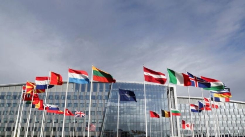 Banderas ondean fuera de la sede de la OTAN antes de una reunión de los ministros de defensa de la alianza en Bruselas el 21 de octubre de 2021. (Pascal Rossignol/Reuters)