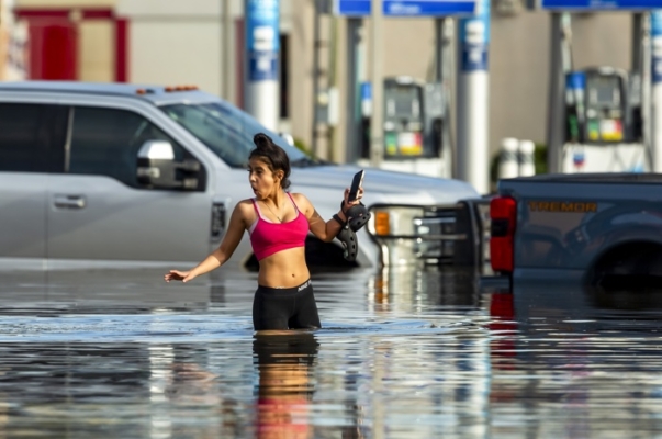 Una mujer camina por las aguas de las inundaciones tras las fuertes lluvias del huracán Beryl en Houston, Texas, EE. UU., 08 de julio de 2024. (Carlos Ramirez/EFE/EPA)