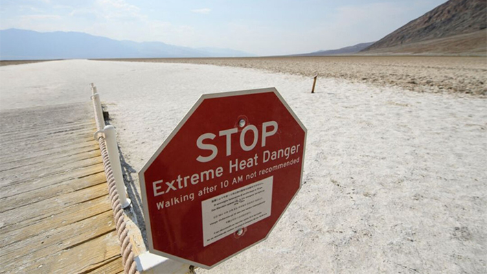 Una señal advierte del peligro del calor extremo en las salinas de Badwater Basin, en el Parque Nacional del Valle de la Muerte, el 17 de junio de 2021, en el condado de Inyo, California. (Patrick T. Fallon/AFP vía Getty Images)
