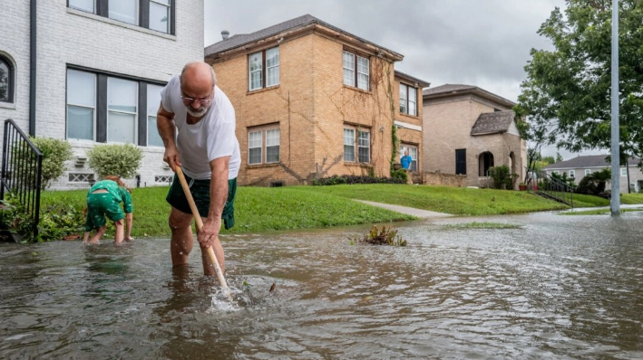 Jack Reyna y su hijo trabajan para drenar el agua de las inundaciones en su barrio después de que el huracán Beryl arrasara la zona en Houston el 8 de julio de 2024. (Brandon Bell/Getty Images)