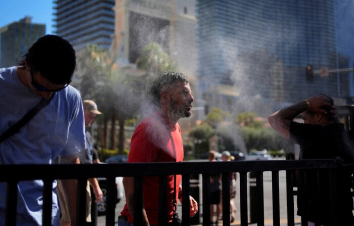 Un grupo de personas se refresca con los nebulizadores en el Strip de Las Vegas el 7 de julio de 2024. (John Locher/Foto AP)
