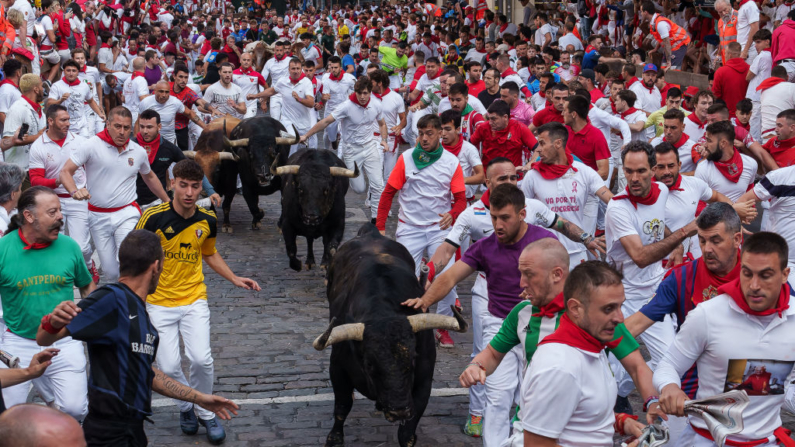 Participantes corren con toros de Fuente Ymbro durante el cuarto encierro de las fiestas de San Fermín en Pamplona, norte de España, el 10 de julio de 2024. (Cesar Manso/AFP vía Getty Images)