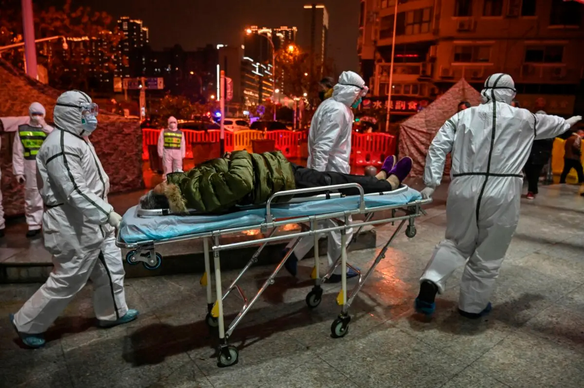 Miembros del personal médico con ropa protectora llegan con un paciente al Hospital de la Cruz Roja de Wuhan en Wuhan, provincia de Hubei, el 25 de enero de 2020. (Hector Retamal/AFP vía Getty Images)