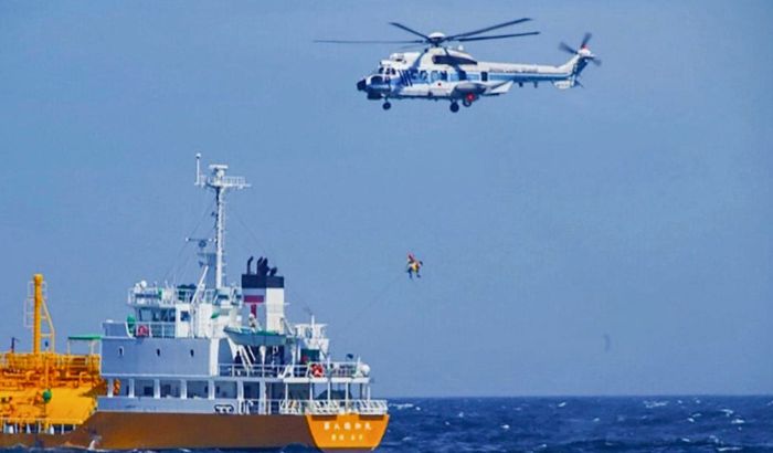 Una mujer es transportada por un helicóptero de la guardia costera frente a Nojimazaki, prefectura de Chiba, Japón, el 10 de julio de 2024. (Guardia Costera de Japón vía AP)