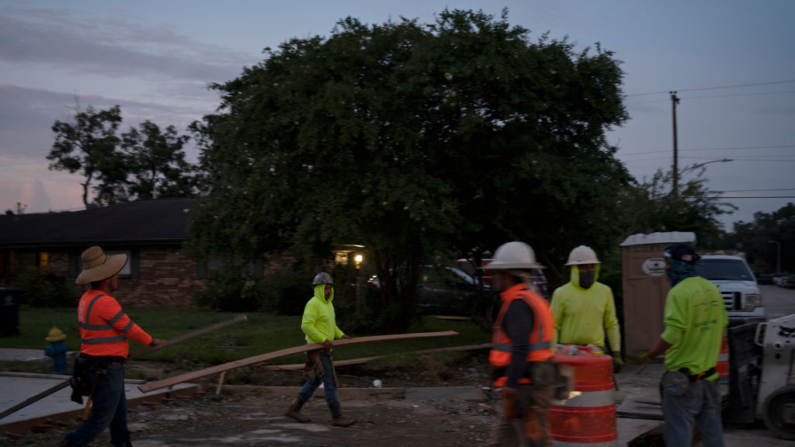 Trabajadores reparan una carretera con un alumbrado público mínimo el 11 de julio de 2024 en Houston, Texas. (Danielle Villasana/Getty Images)