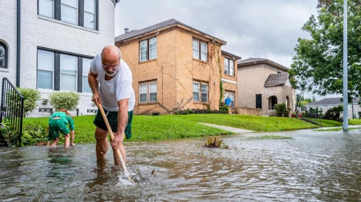 Jack Reyna y su hijo trabajan para drenar el agua de la inundación en su vecindario después de que el huracán Beryl azotara el área en Houston el 8 de julio de 2024. (Brandon Bell/Getty Images)