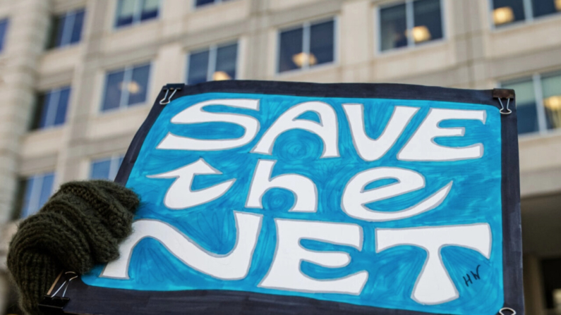 Una mujer sostiene un cartel de protesta que dice "Salven la Red" durante una manifestación en contra de la propuesta de derogación de la neutralidad de la red frente a la sede de la Comisión Federal de Comunicaciones en Washington, el 13 de diciembre de 2017. (Alex Edelman / AFP via Getty Images)