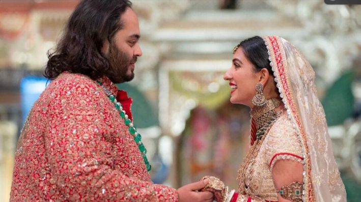 Anant Ambani, hijo del multimillonario Mukesh Ambani, se toma de la mano de Radhika Merchant durante su ceremonia de boda en el Centro de Convenciones Jio World en Mumbai, India, el 12 de julio de 2024. (Refiliance Industries a través de AP)