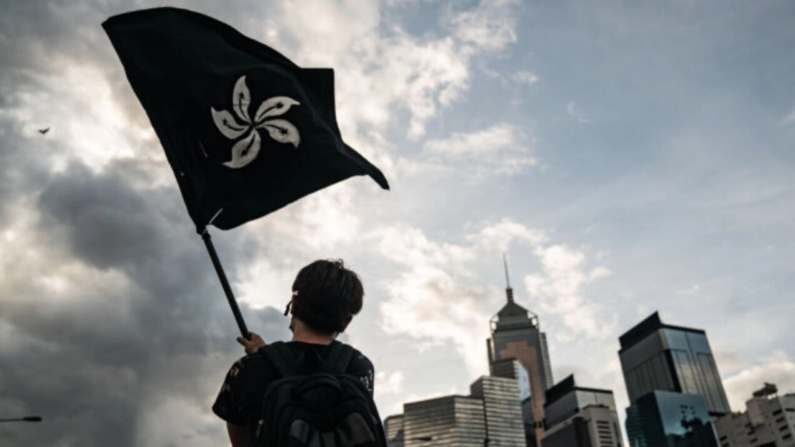 Un hombre ondea una bandera negra de Hong Kong en una calle cerca del Complejo del Consejo Legislativo en Hong Kong el 1 de julio de 2019. (Anthony Kwan/Getty Images)