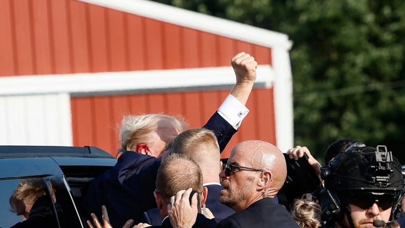 El candidato presidencial republicano, Donald Trump, levanta el puño mientras lo suben a un automóvil después de un atentado en un mitin, el 13 de julio de 2024 en Butler, Pensilvania. (Anna Moneymaker/Getty Images)