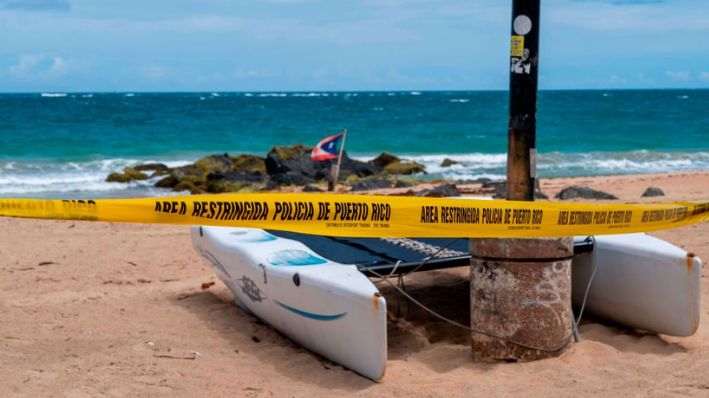 Una foto de archivo de una cinta policial que restringe el acceso a la playa en la zona turística de El Condado en San Juan, Puerto Rico. (RICARDO ARDUENGO/AFP vía Getty Images)