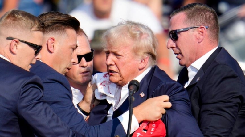 El candidato presidencial republicano, el expresidente Donald Trump, es ayudado a bajar del escenario en un acto de campaña en Butler, Pensilvania, el 13 de julio de 2024. (Gene J. Puskar/Foto AP)