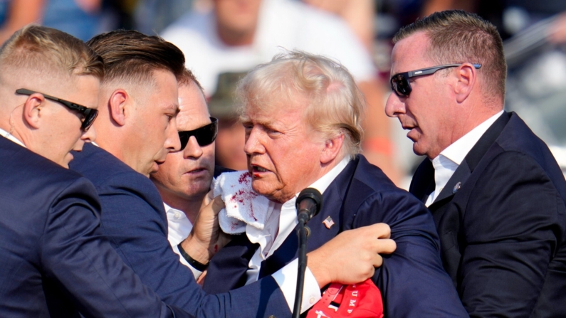 El candidato presidencial republicano, el expresidente Donald Trump, recibe ayuda para bajar del escenario durante un acto de campaña, en Butler, Pensilvania, el 13 de julio de 2024. (Gene J. Puskar/AP Photo)