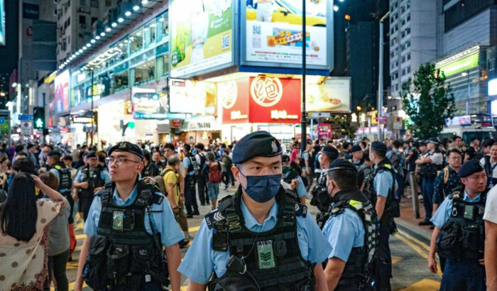 El 4 de junio de 2024, agentes de policía patrullan el distrito de Causeway Bay de Hong Kong, cerca del Parque Victoria, donde la gente se reunía anualmente como tradición para llorar a las víctimas de la represión de la Plaza de Tiananmen en China en 1989. Desde que entró en vigor la nueva ley de seguridad nacional, el evento ya no se lleva a cabo. (Anthony Kwan/Getty Images)