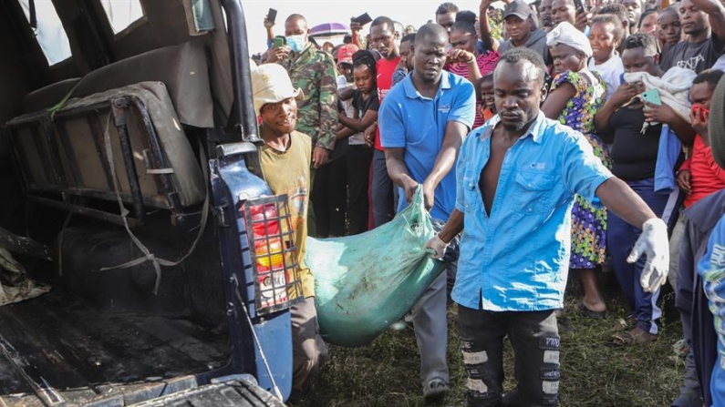 Un grupo de hombres transporta un cuerpo envuelto en una bolsa recuperada del interior de una cantera convertida en vertedero en la zona de Embakasi en Nairobi, Kenia, el 12 de julio de 2024. EFE/EPA/Stringer 