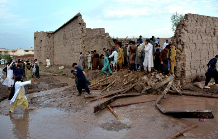 La gente se reúne para limpiar los escombros de una casa parcialmente dañada por un deslizamiento de tierra debido a las fuertes lluvias en el distrito de Surkhroad de Jalalabad, provincia de Nangarhar, al este de Kabul, Afganistán, el 15 de julio de 2024. (Shafiullah Kakar/AP Photo)
