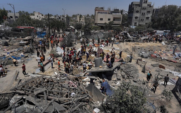 Palestinos observan los escombros de tiendas de campaña destruidas y estructuras de vivienda improvisadas luego de un ataque militar israelí en el campamento de desplazados internos de al-Mawasi, cerca de la ciudad de Khan Yunis, en el sur de la Franja de Gaza, en el que murieron 90 personas, según informaron funcionarios de salud palestinos, el 13 de julio de 2024. (Bashar Taleb/AFP vía Getty Images)
