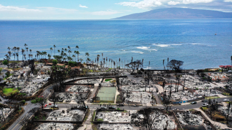 En una vista aérea, un vehículo de recuperación pasa por delante de estructuras y coches quemados dos meses después de un devastador incendio forestal el 09 de octubre de 2023 en Lahaina, Hawái. (Mario Tama/Getty Images)